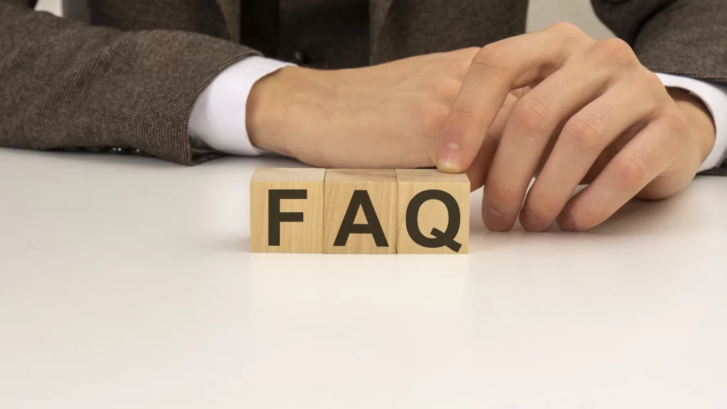 a picture of hands holding FAQ wooden blocks for frequently asked questions on the blog topic