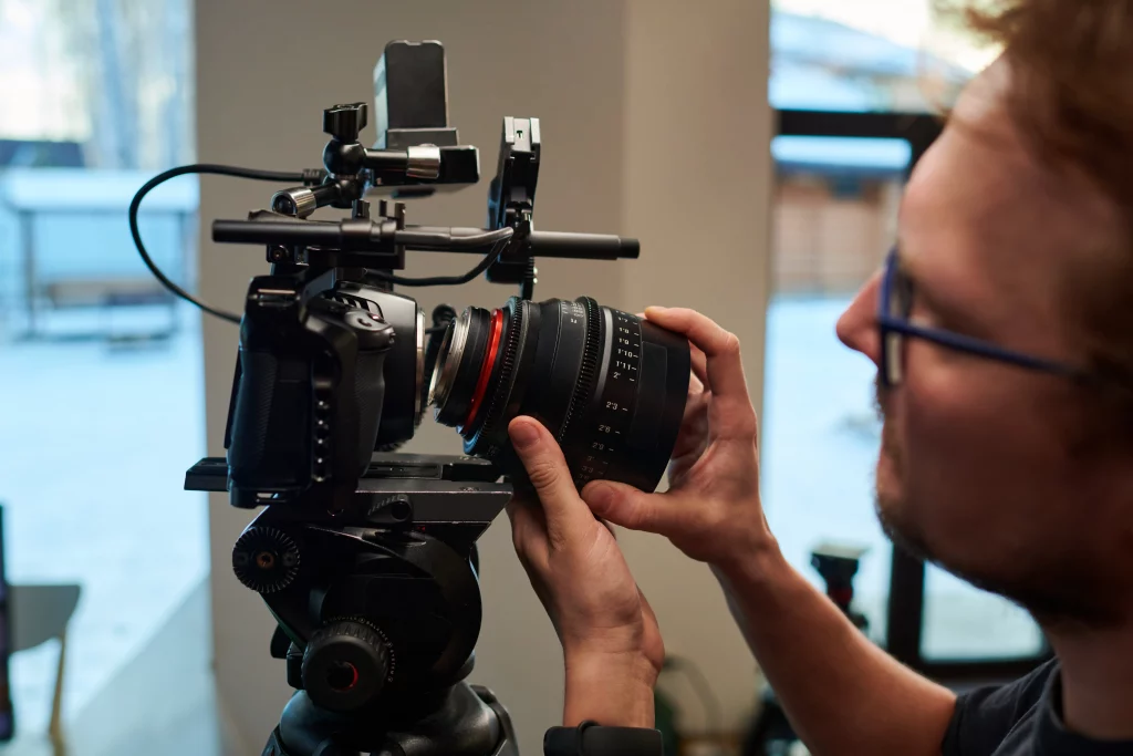 a videographer turning video camera lens