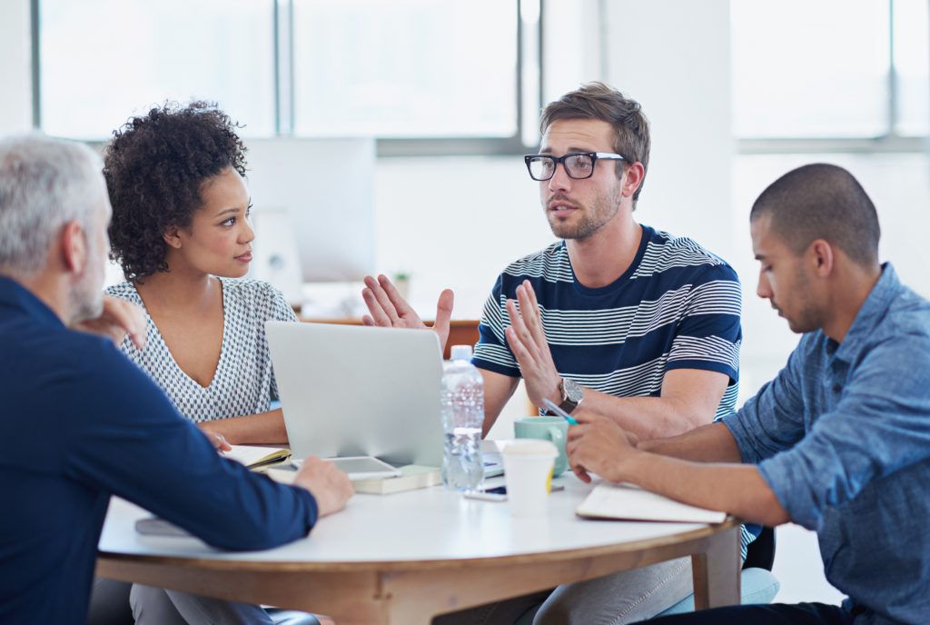 A meeting between four people at a table discussing if you can dismiss an employee for being drunk at work