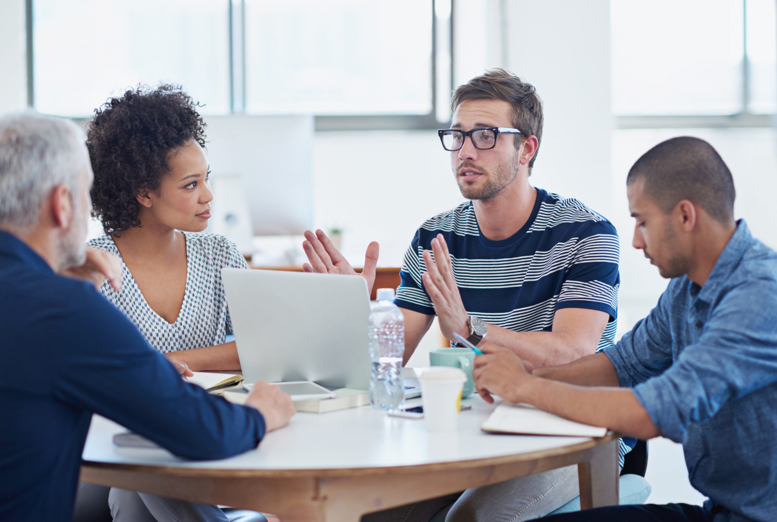 A meeting between four people at a table discussing if you can dismiss an employee for being drunk at work