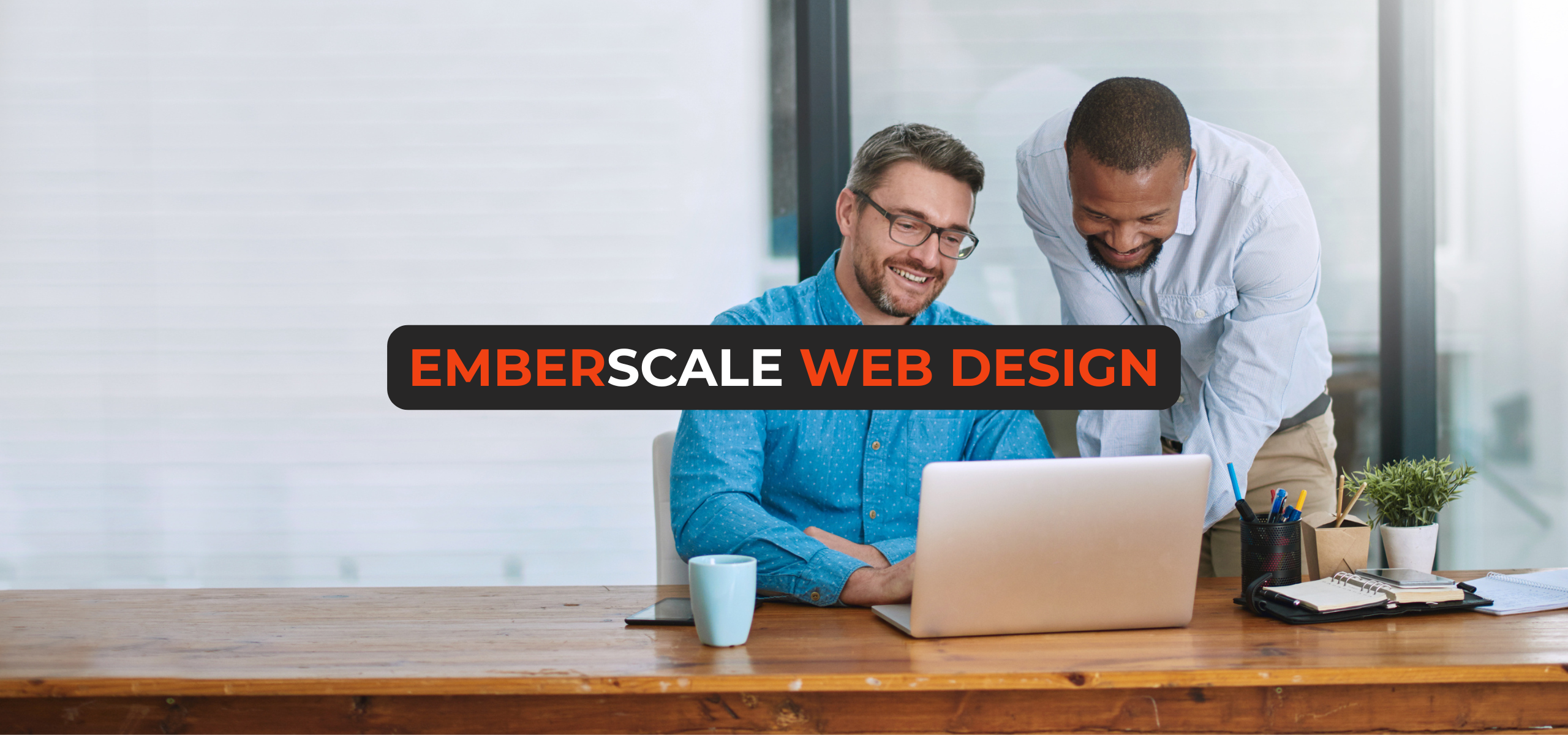 Two smiling professionals—a web designer and a small business owner—collaborating over a laptop in a bright modern office, discussing web design services.