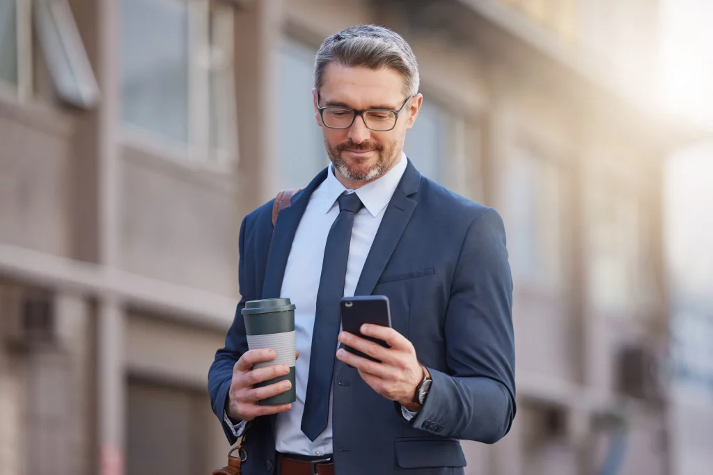 a business owner smiling holding a coffee preparing to contact emberscale for a free consultation